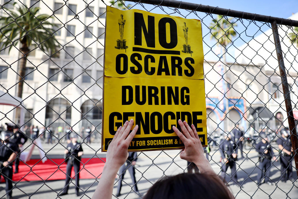 متظاهرون مؤيدون لفلسطين يتظاهرون بينما تراقب الشرطة مدخل حفل توزيع جوائز الأوسكار الـ96، 10 مارس 2024 هوليوود، كاليفورنيا.