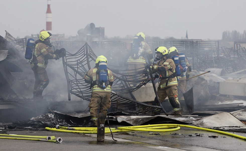 أفراد الطوارئ يقومون بإطفاء الحريق الذي اندلع في مخيم للاجئين الأوكرانيين في برلين على أراضي مطار 
