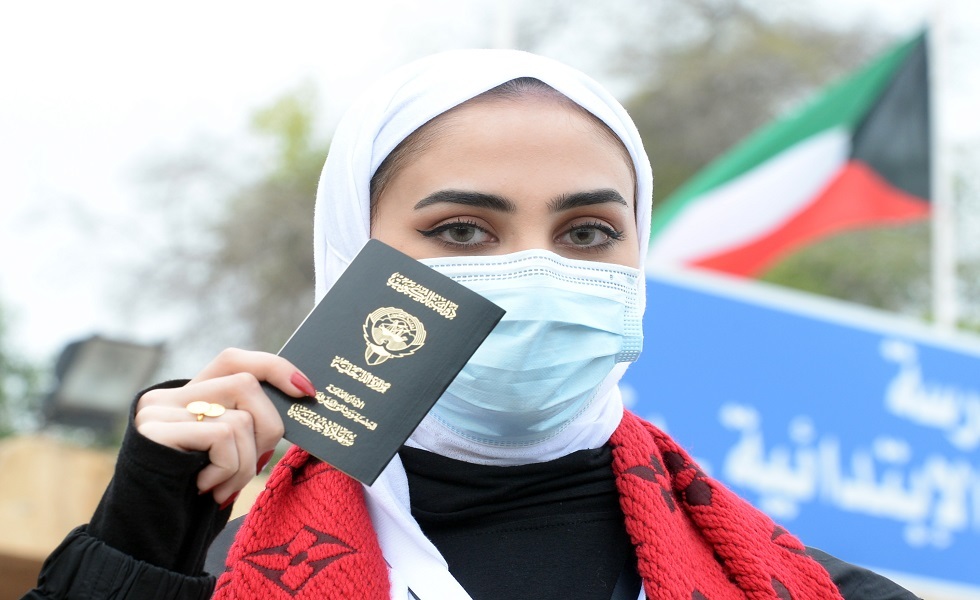 سيدة تبرز جواز السفر الكويتي قبل دخولها مركز اقتراع في محافظة حولي - ديسمبر 2020.