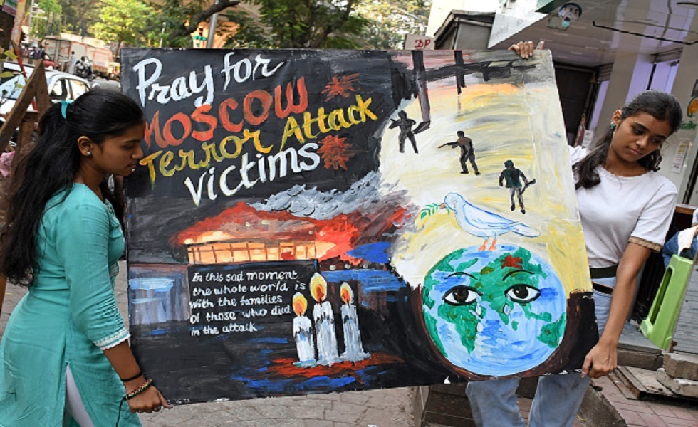 مومباي - طالبات مدرسة غوروكول للفنون ولوحة تطلب الصلاة لضحايا هجوم كروكوس الإرهابي في موسكو.