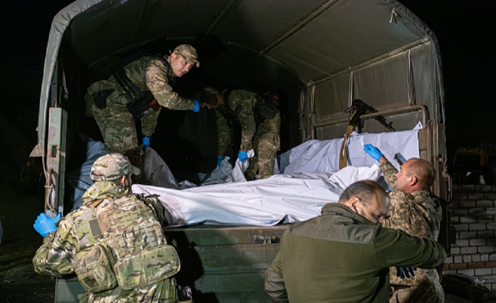 جنود أوكرانييون ينقلون جثث لقتلى جيشهم