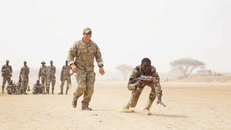 ضابط بالجيش الأميركي يتابع جندي بالجيش النيجري خلال تدريبات عسكرية في ديفا بالنيجر.