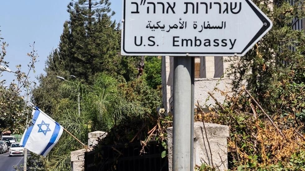 علم إسرائيلي معروض أمام مبنى بالقرب من لافتة طريق للسفارة الأمريكية في القدس