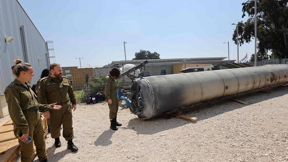 أفراد من الجيش الإسرائيلي يقفون بجانب صاروخ باليستي إيراني سقط في إسرائيل
