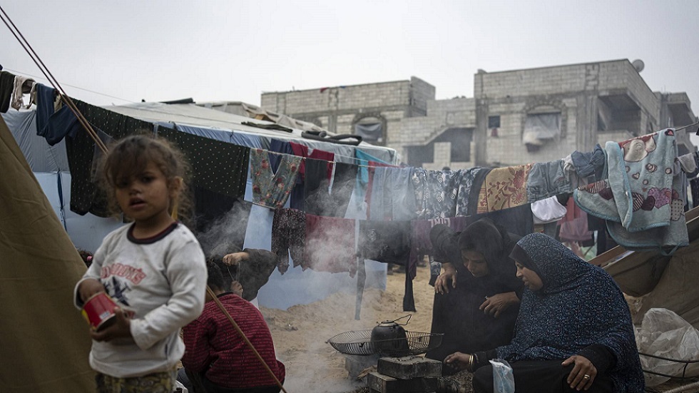 فلسطينيون نازحون بسبب القصف الإسرائيلي على قطاع غزة يطبخون في مخيم الخيام المؤقت بمنطقة المواصي