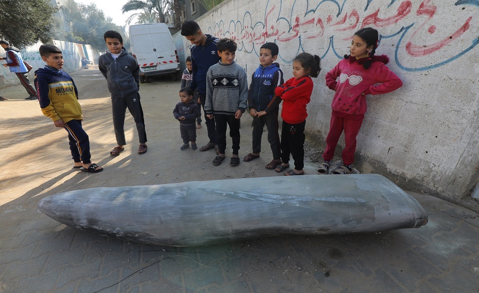 أطفال في غزة يقفون أمام صاروخ إسرائيلي لم ينفجر خلال الهجوم على غزة