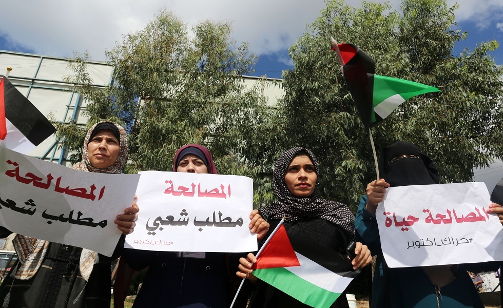 صورة أرشيفية لنساء فلسطينيات يحملن لافتات خلال مسيرة دعم للمصالحة الفلسطينية في غزة