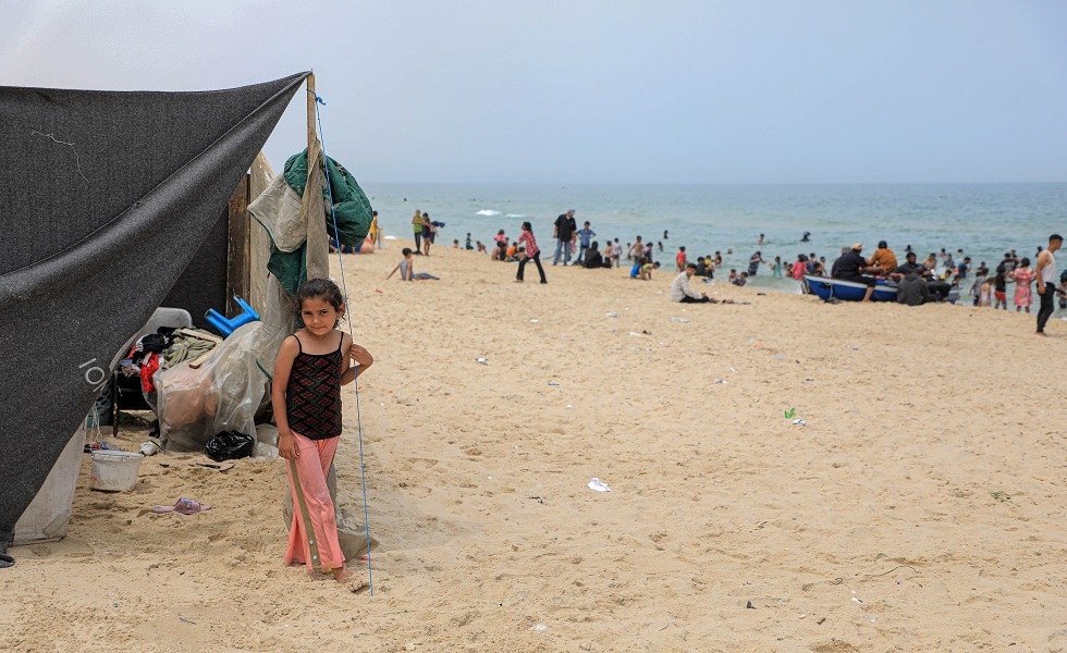 فتاة فلسطينية تم إجلاؤها من رفح تقف بجوار خيمة على شاطئ مدينة خان يونس - 10 مايو 2024.
