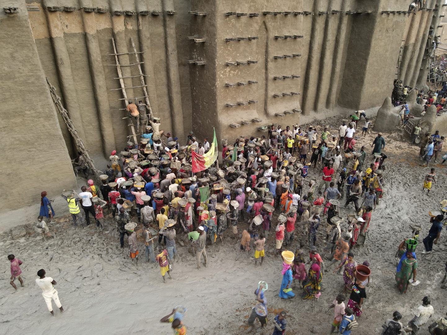 آلاف المواطنين في مالي يشاركون بترميم أكبر مسجد طيني في العالم (صور)