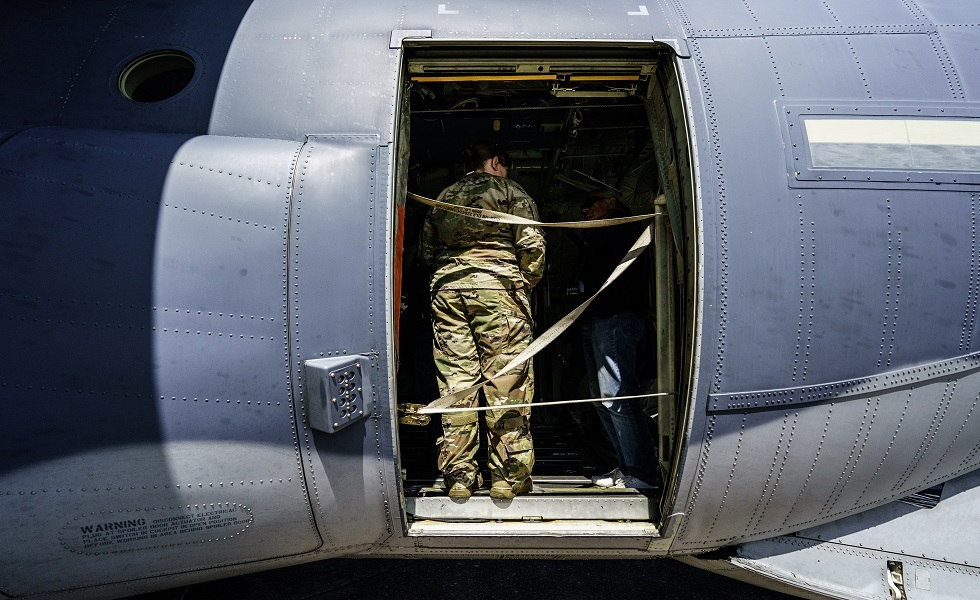 جندي أمريكي أمام باب طائرة عسكرية في إحدى القواعد الأمريكية