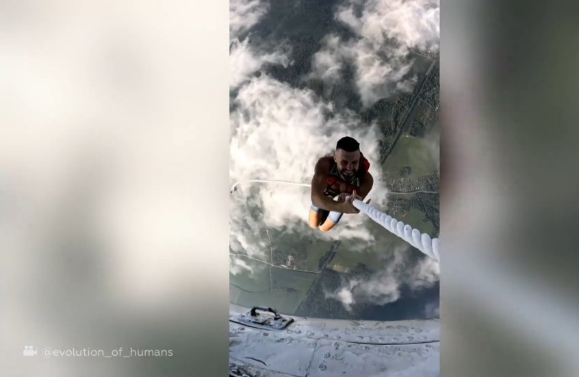 مغامر روسي يتسلق على حبل معلق بطائرة قبل أن يقفز منها بالمظلة