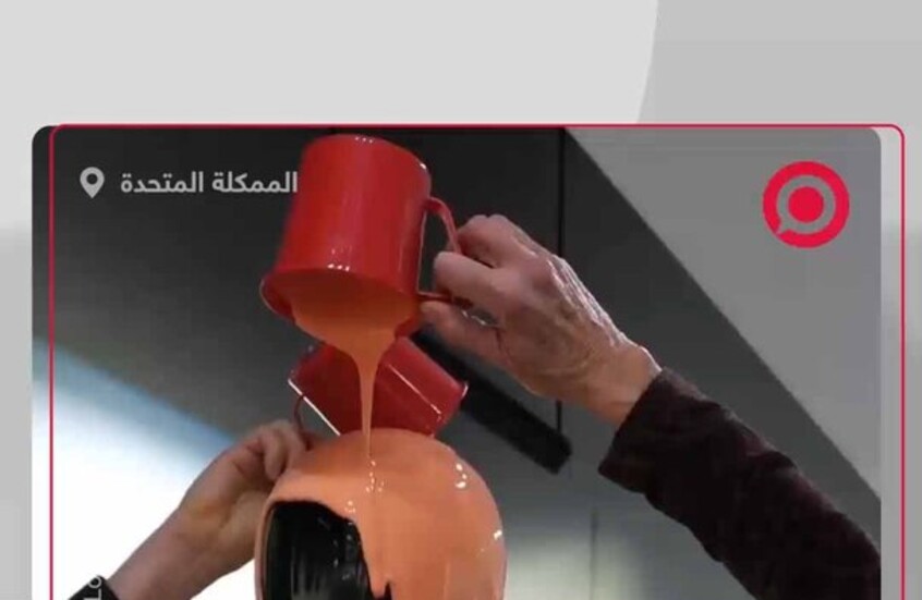 ناشطان بيئيان يسكبان سائلا برتقاليا على روبوت "أوبتيموس" في معرض "تسلا"