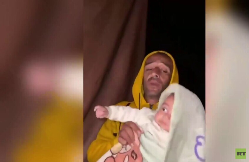 قطاع غزة.. أب ينقذ طفله من خيمة غمرتها مياه الأمطار