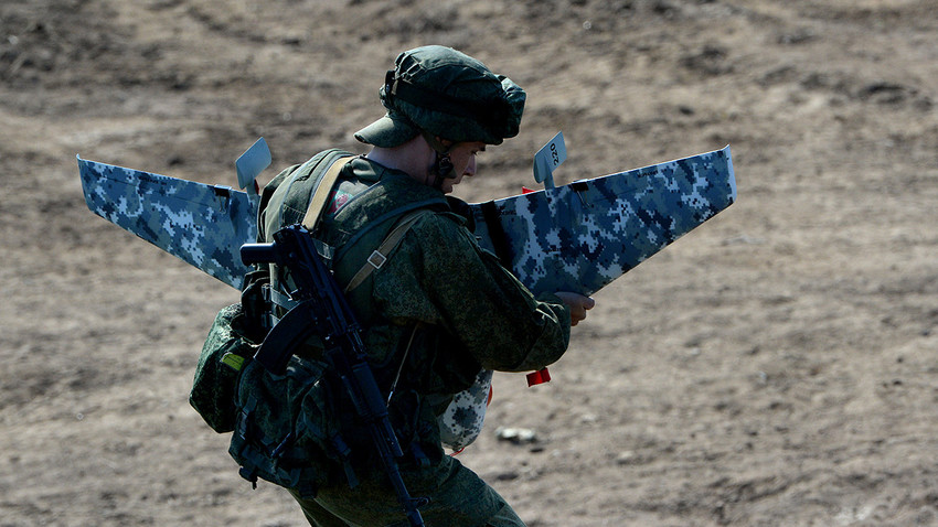 Seorang tentara Rusia bersiap-siap menerbangkan sebuah drone.