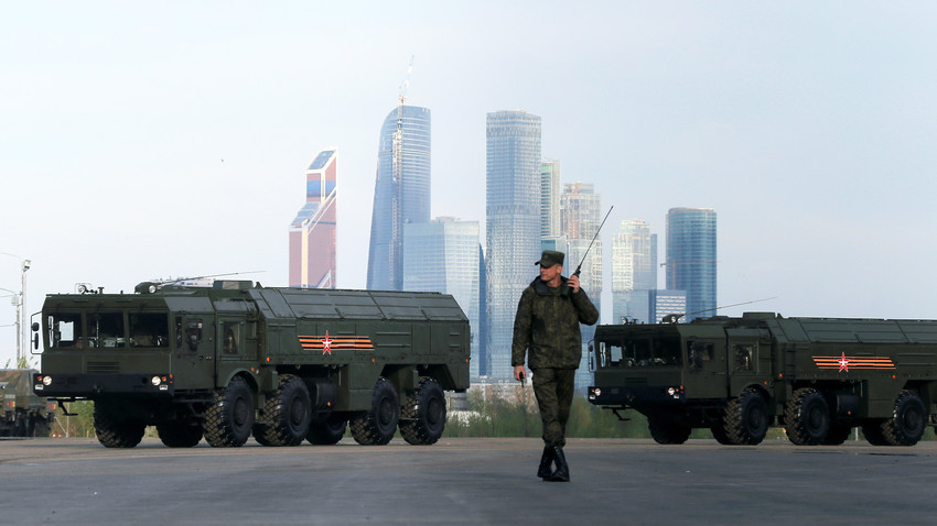A Russian serviceman walks past Russian Iskander-M missile launchers with the Moscow International Business Center also known as "Moskva-City" seen in the background, at a range in Moscow, Russia.