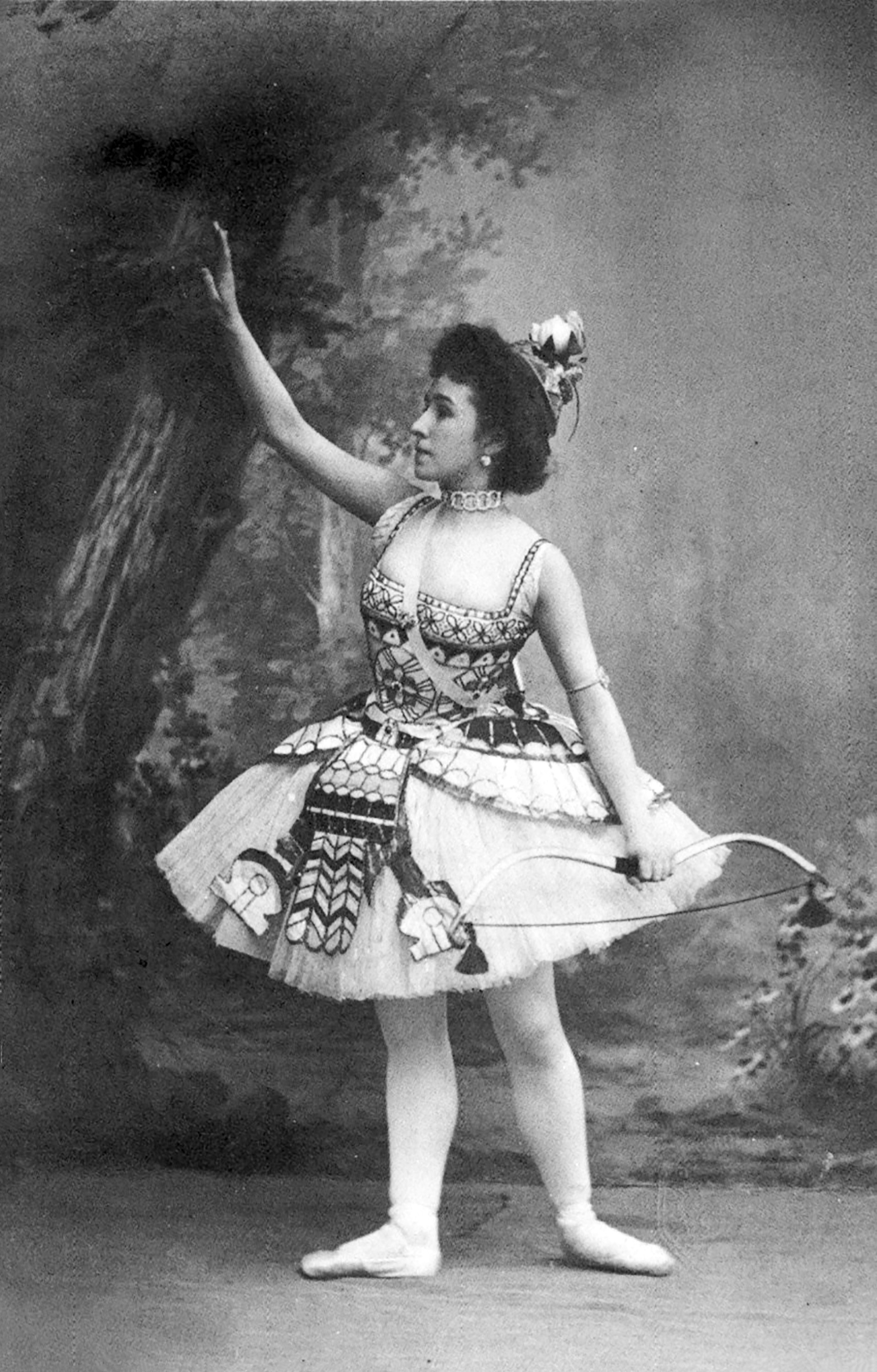 Photographic postcard of Mathilde Kschessinska costumed as the Princess Aspicia in the Grand pas des chasseresses from 'The Pharaoh's Daughter' ballet, 1898-1899