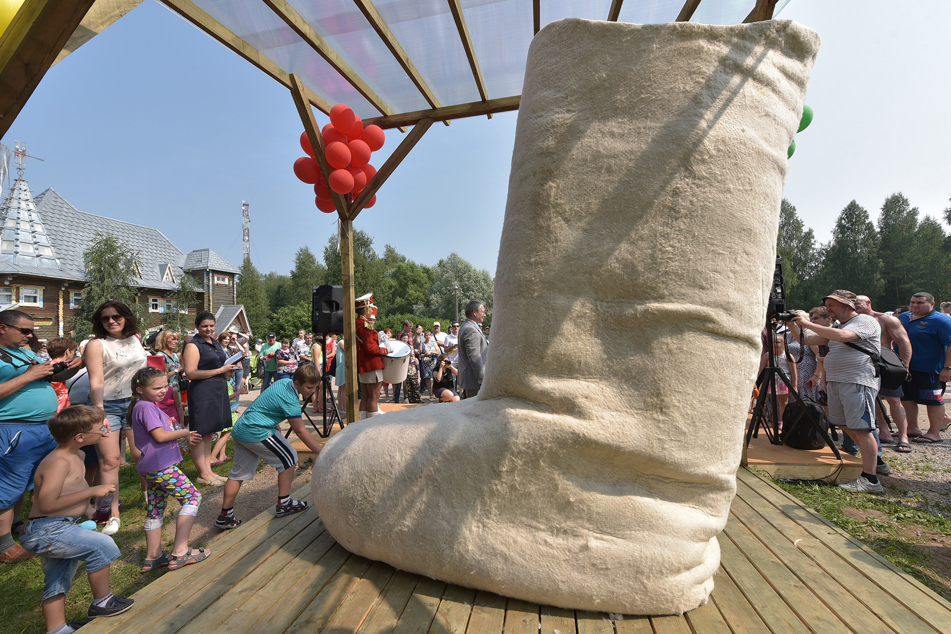 People look at a giant valenki boot made by artist Valeria Loshak