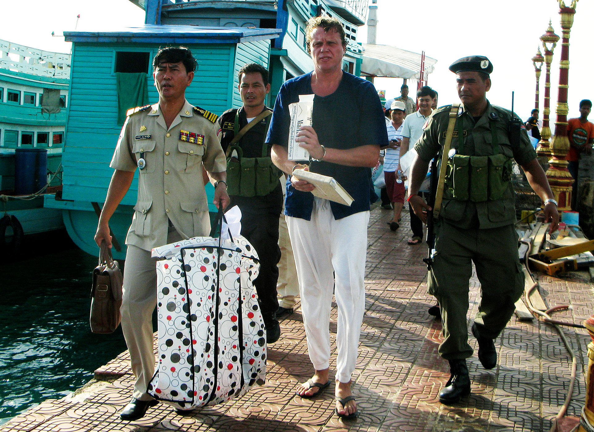 Sergei Polonsky is escorted by Cambodian police officers