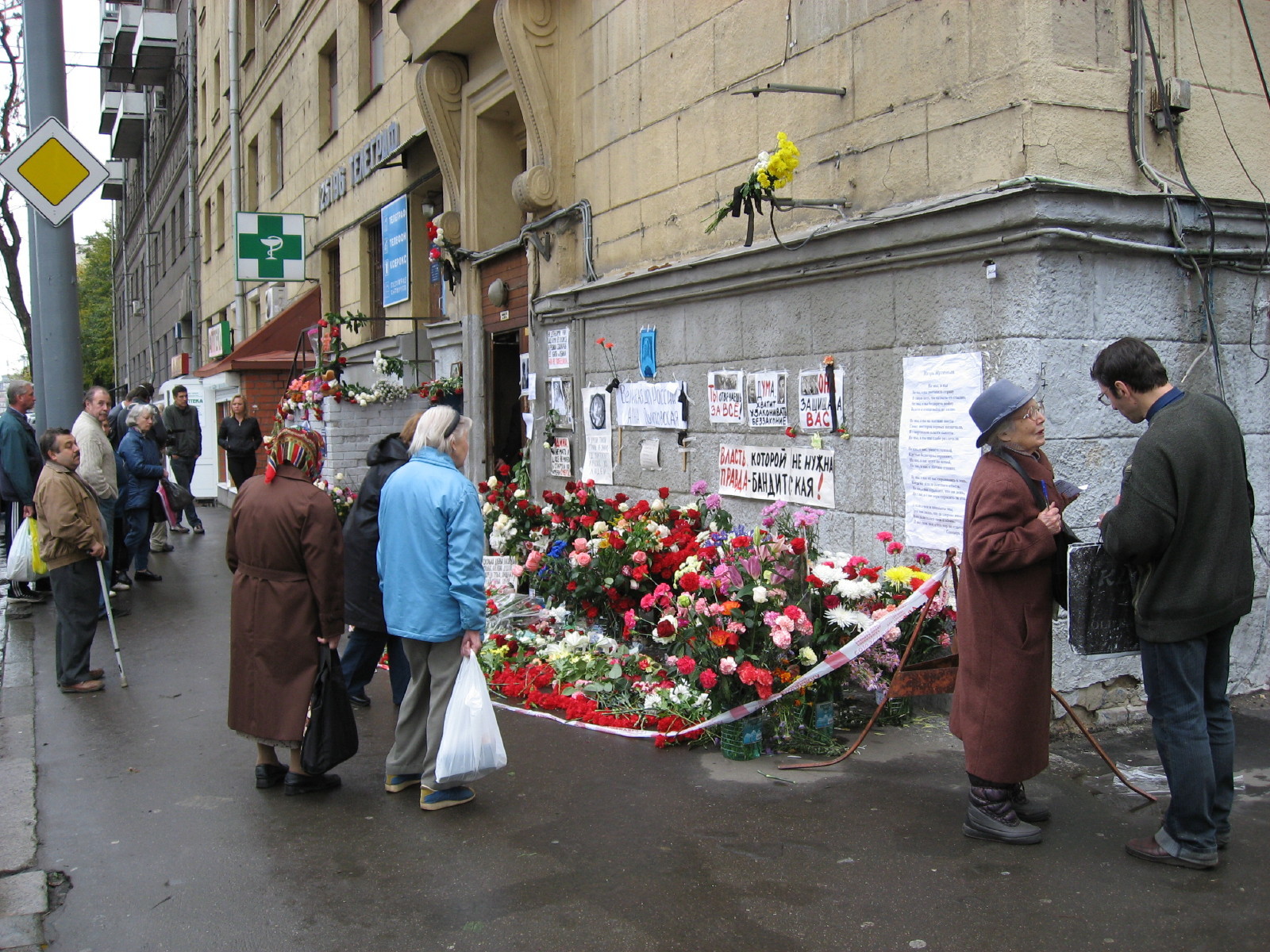Menschen legen Blumen am Haus der Journalistin Politkowskaja ab