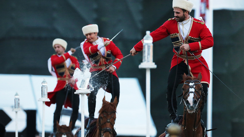 Членове на Кавалерийния ескорт на президентския полк в Кремълското училище по езда изпълняват акробатичен номер на Червения площад на Международния фестивал за военна музика "Спаская кула" през 2016 година.