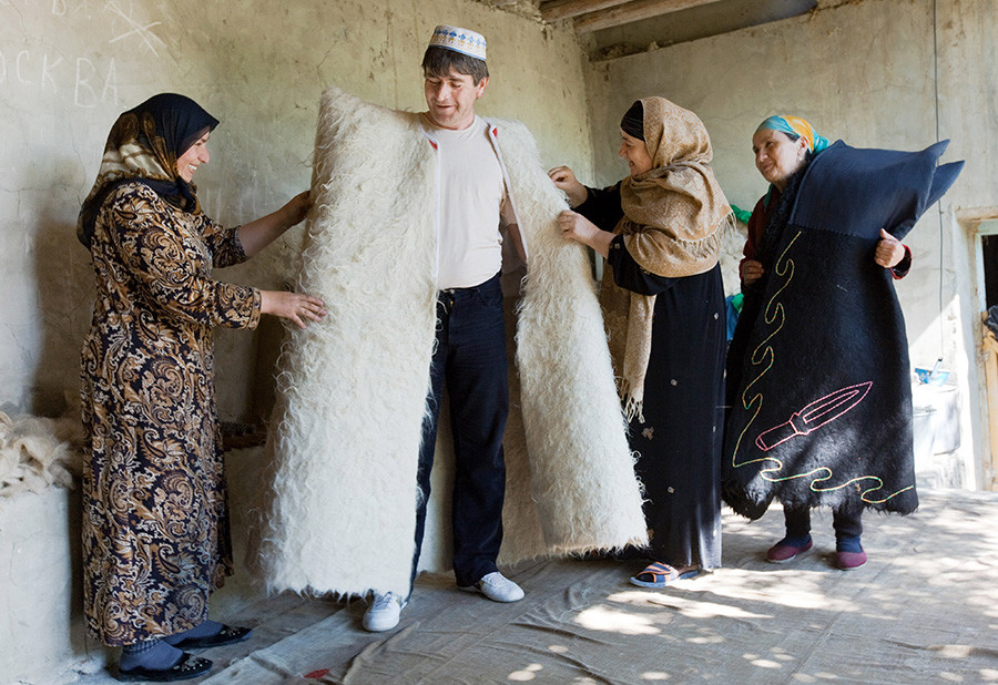 Oblačenje končane burke. Ženske iz družine Abutalipovih iz dagestanske vasi Rahata delajo burke - tradicionalna oblačila kavkaških ljudstev. Na Kavkazu danes obstaja le nekaj družin, ki se ukvarjajo s to obrtjo. 