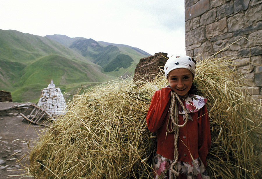 A girl carrying hay during the harvest in Dagestan, Agulsky Region, Russia