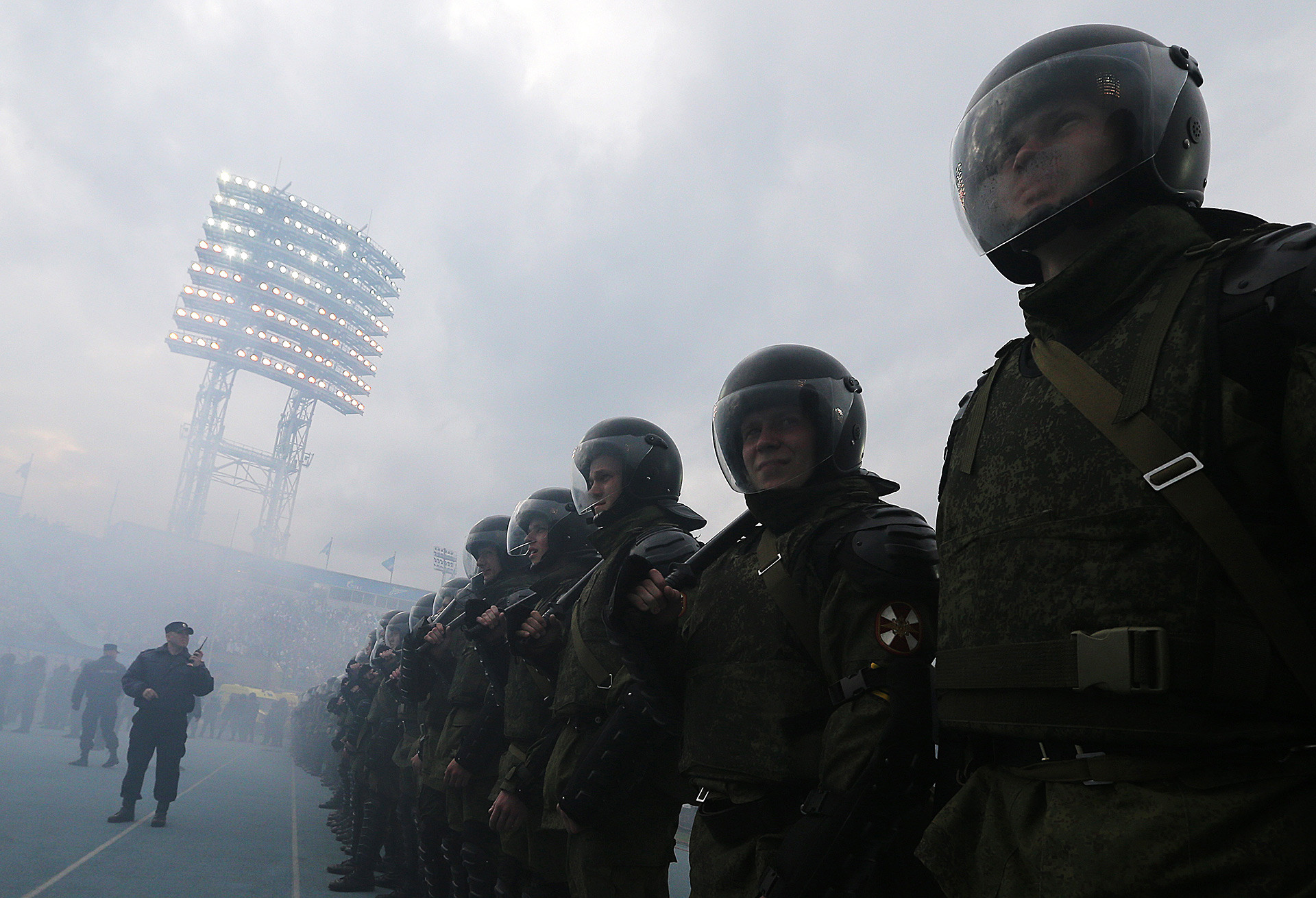 Agentes de policía observan mientras ultras lanzan bengalas durante la Liga Rusa 2014/2015.
