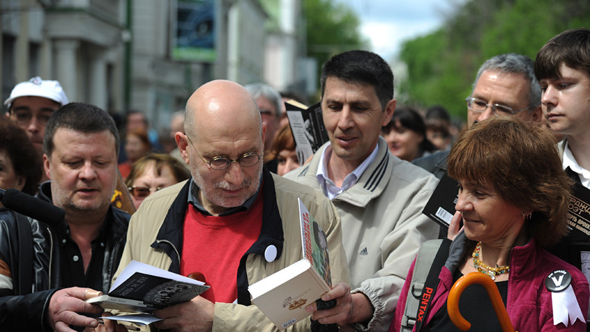 Akúnin (de tricô vermelho) dá autografos durante a “Marcha de Controle”, evento da oposição organizado por escritores de renome na Rússia. 
