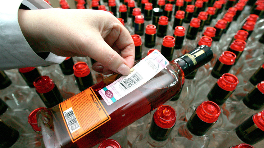 Employees at the "SPI-RVVC" distillery paste excise duty stamps on the bottled products