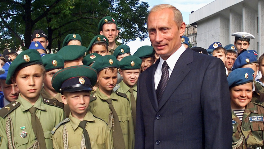 Presiden Putin berfoto dengan anak-anak berseragam militer setelah upacara persembahan ikon Fyodor Ushakov, seorang laksamana dari abad ke-18, kepada Armada Pasifik pada 2002 silam.