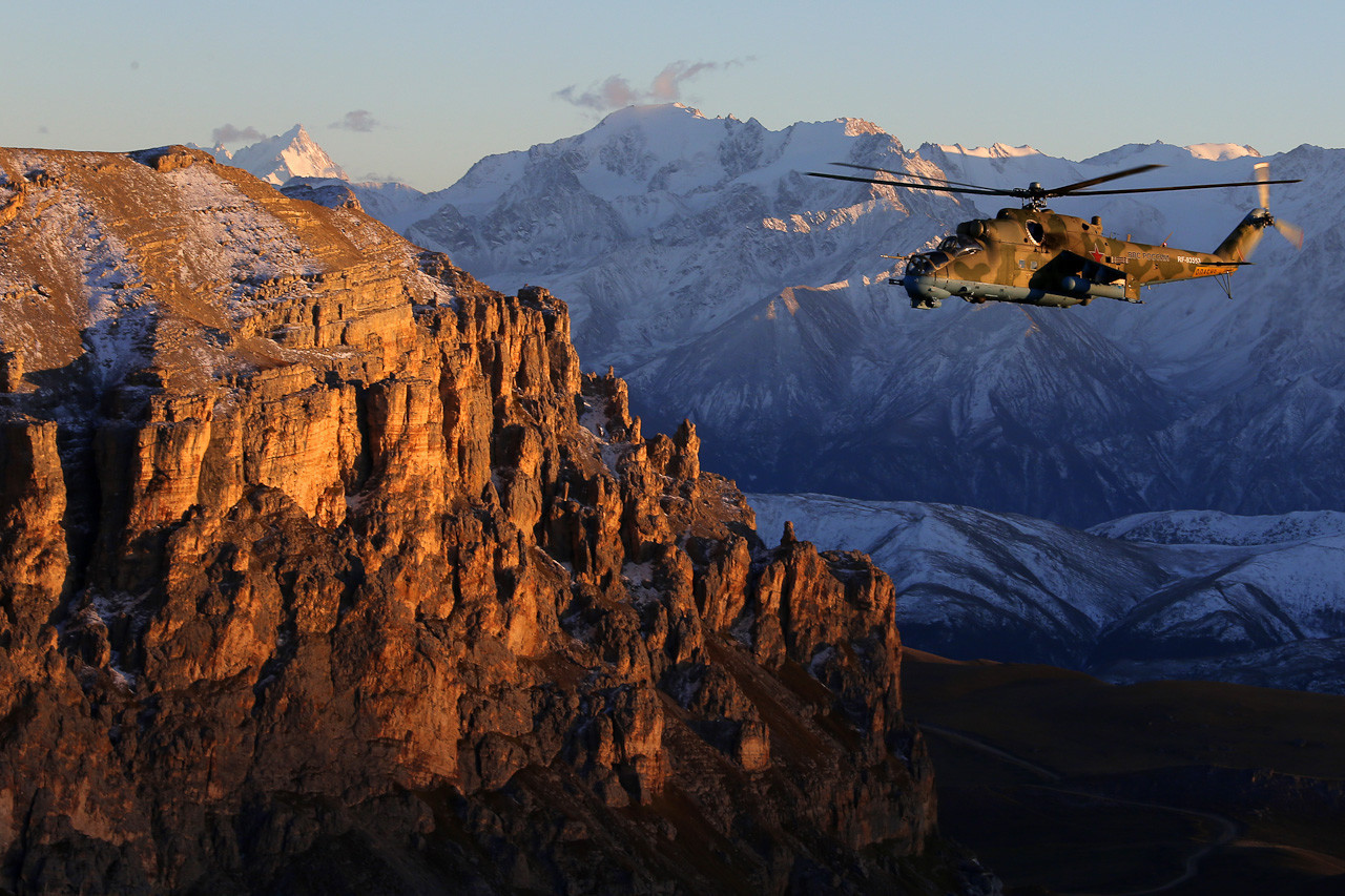 Helikopter Mi-24 leti na Kavkazu u sumrak.
