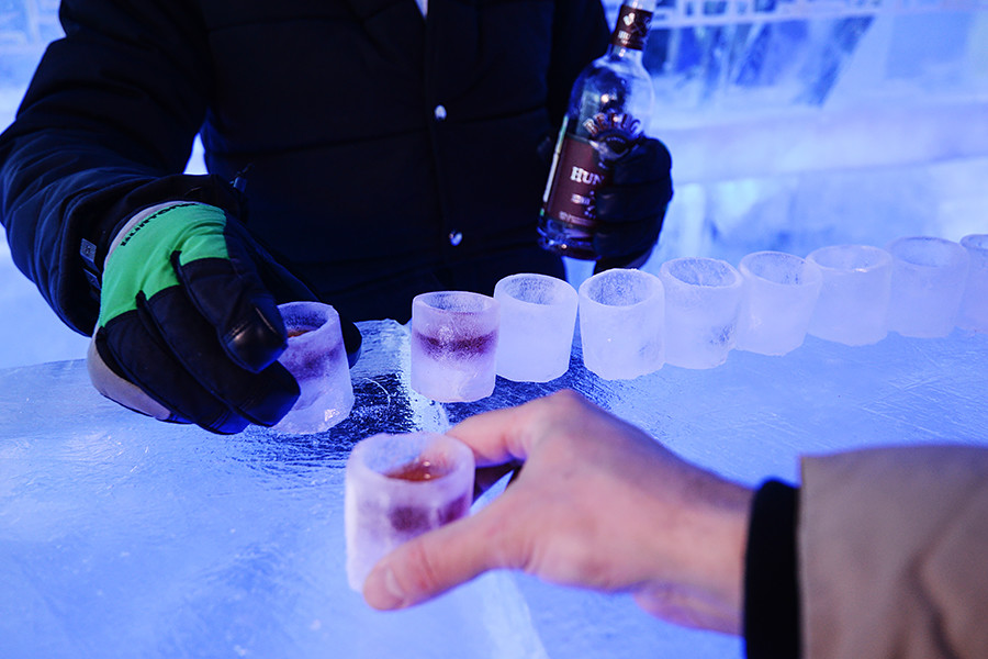 A bartender pours beverage into ice glasses at Twiggy ice bar in Novosibirsk.