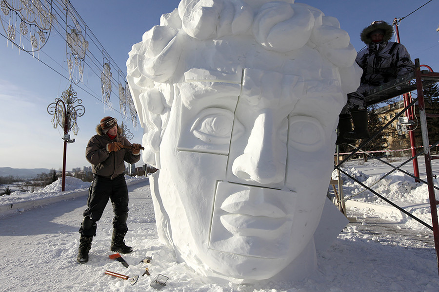 Membros de uma equipe da cidade de Perm, nos Urais, trabalham em escultura de gelo durante o primeiro festival internacional de esculturas de neve e gelo “Gelo Mágico da Sibéria”, em Krasnkoiarsk.