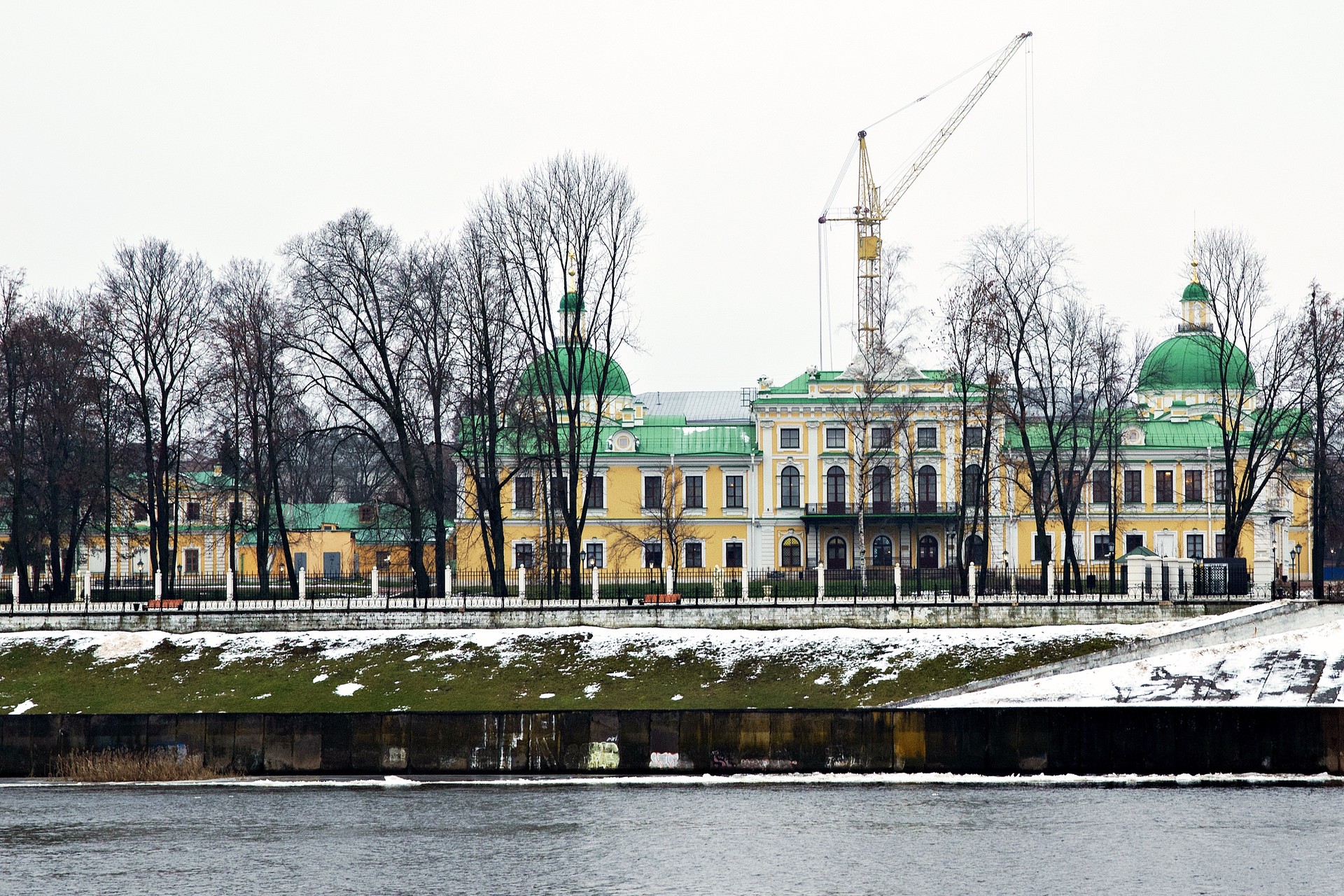Wenn Sie dann über die Alte Stadtbrücke ans gegenüberliegende Wolgaufer spazieren, sehen Sie den kompletten Palast mit seinem Park. Der Kran im Hintergrund gehört zu den Bauarbeiten an einer Kirche direkt vor dem Palast. Diese war zu Zeiten Stalins gesprengt worden und wird nun wieder aufgebaut.