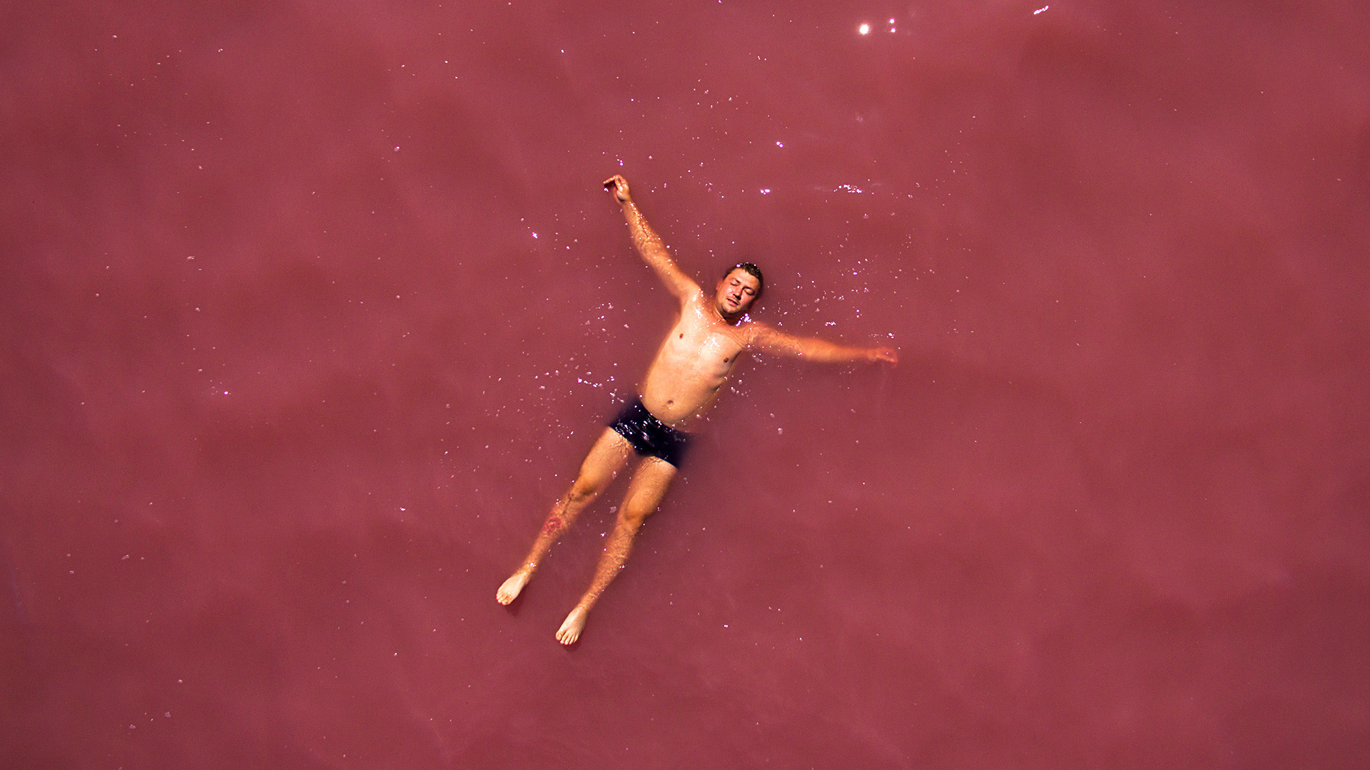 アルタイ地方の塩湖“マリノヴォエ・オゼロ”（ラズベリーの湖）で休む男性