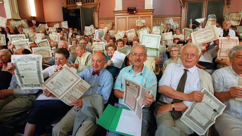Angry holders of Russian bonds hold their title at the Paris courtroom 26 June 2001