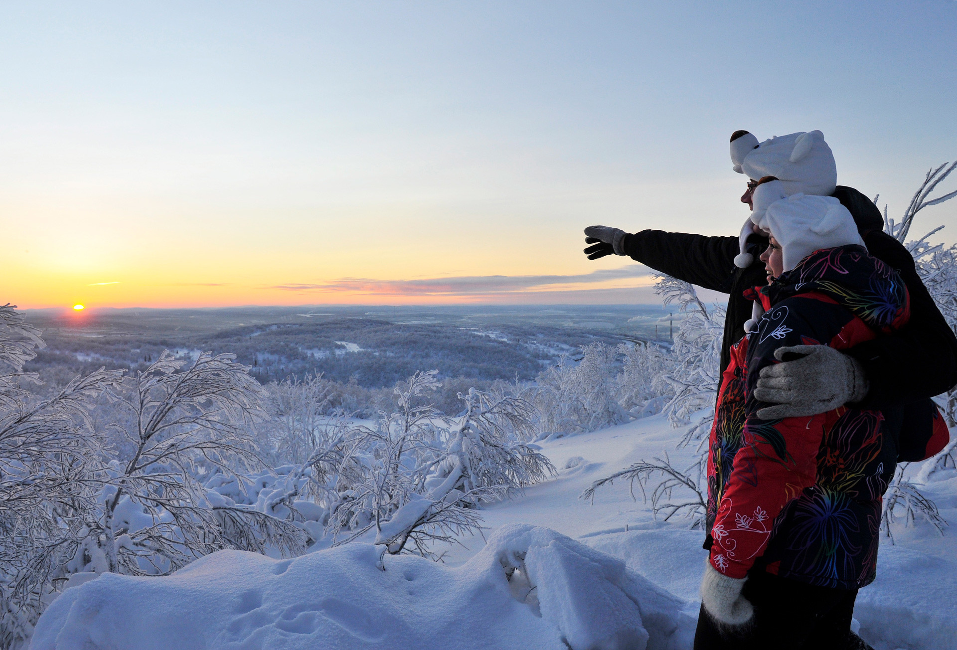 Dua warga Murmansk menyambut matahari terbit untuk pertama kalinya sejak awal Desember 2017 yang menandai berakhirnya malam kutub.