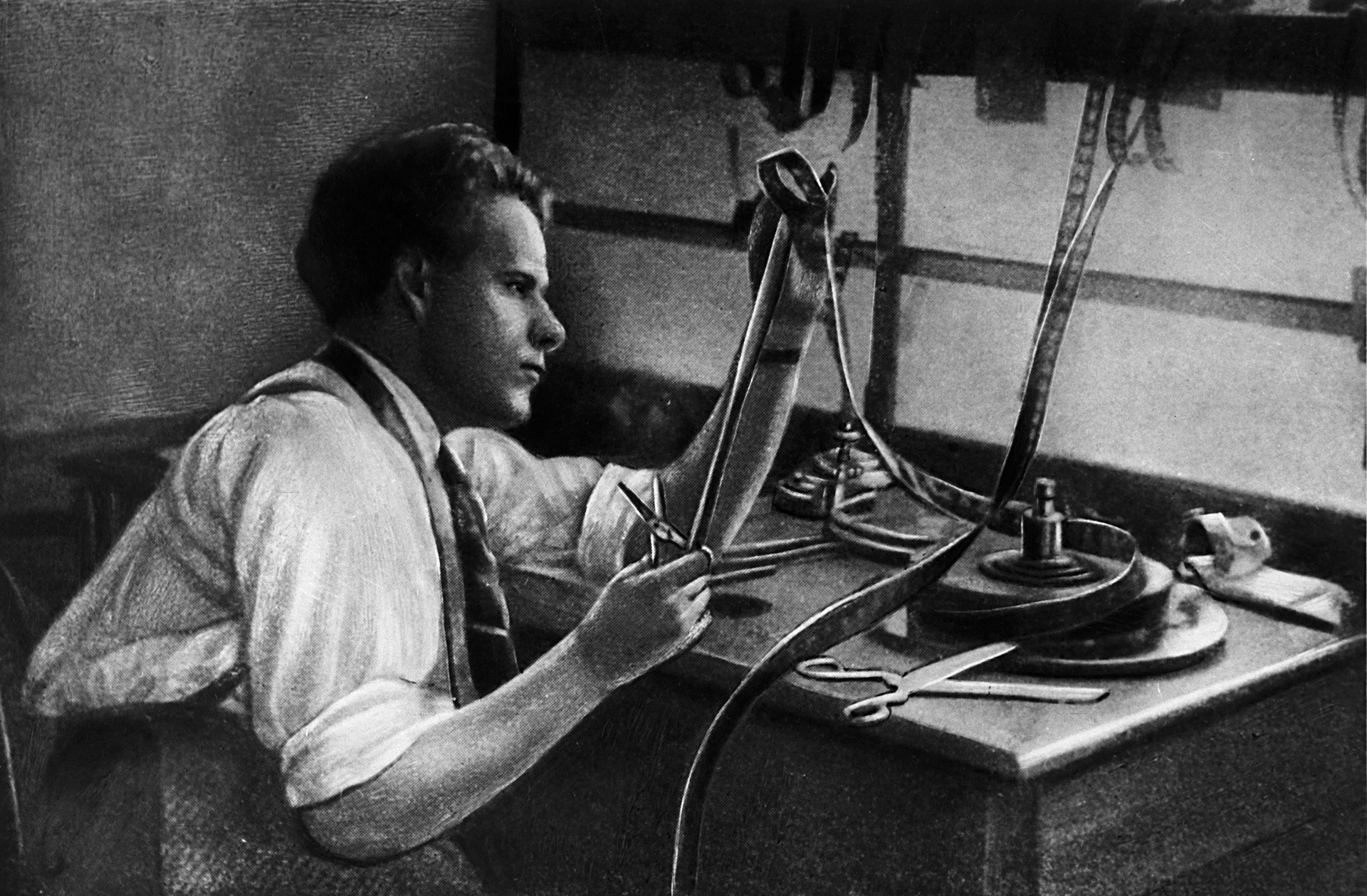 Sergei Eisenstein at the cutting table.1925. Reproduction.