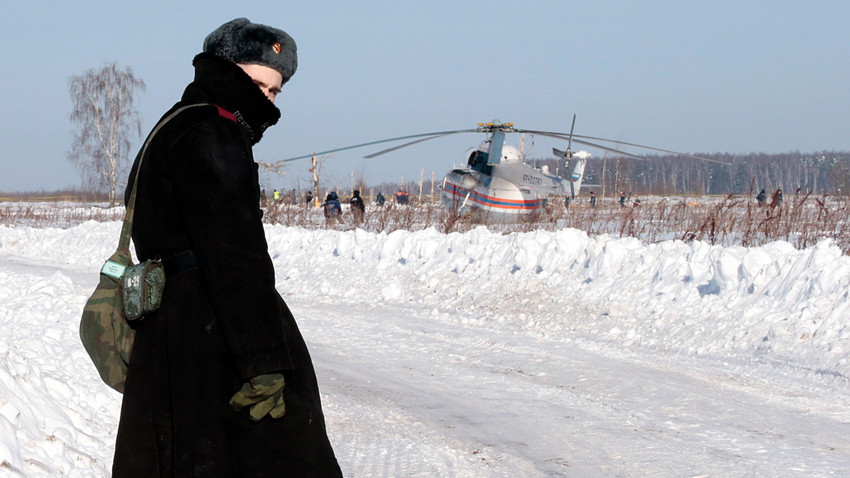 A Russian serviceman looks back as he stands guard during a search operation near the crash site of the short-haul AN-148 airplane operated by Saratov Airlines in Moscow Region.
