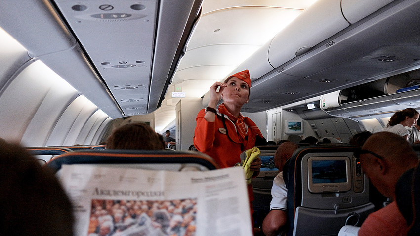 Passengers and a flight attendant aboard an Aeroflot aircraft during flight.