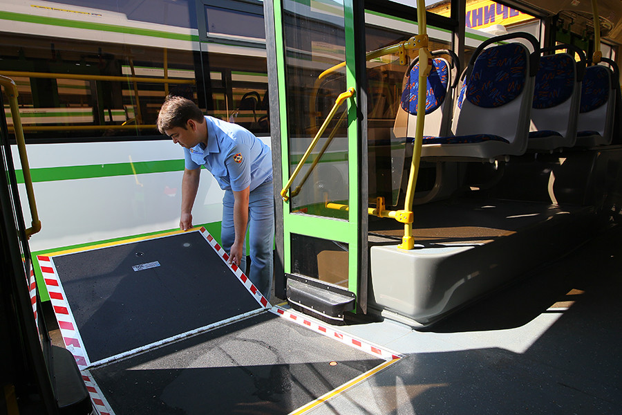 A driver checks the operation of a wheelchair ramp