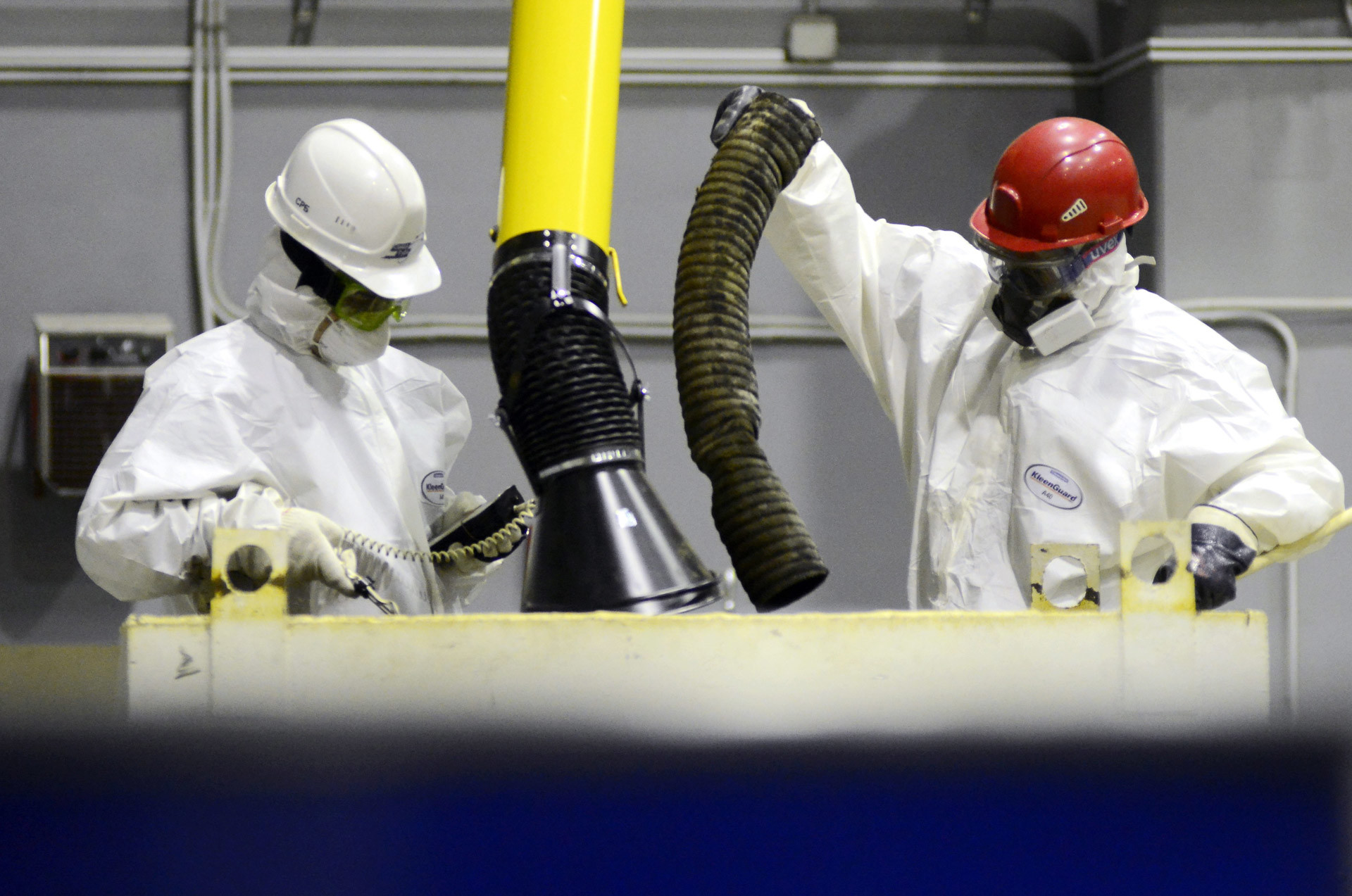 Trabajadores prensan y secan desechos radiactivos sólidos en un taller en la planta de reprocesamiento, acondicionamiento y almacenamiento de desechos radiactivos.