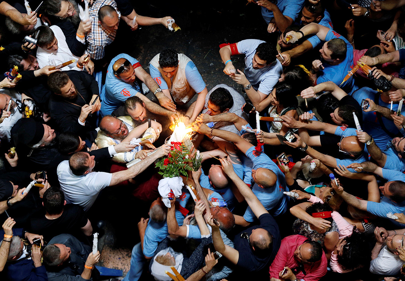 Jemaat menyalakan lilin dalam perayaan Api Suci Ortodoks di Gereja Makam Kudus di Yerusalem.