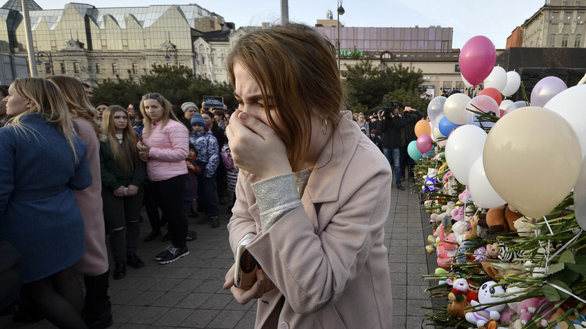 Mulher aos prantos durante evento para homenagear as vítimas da tragédia de Kemerovo. Foram registradas mais 30 reuniões do tipo em toda a Rússia