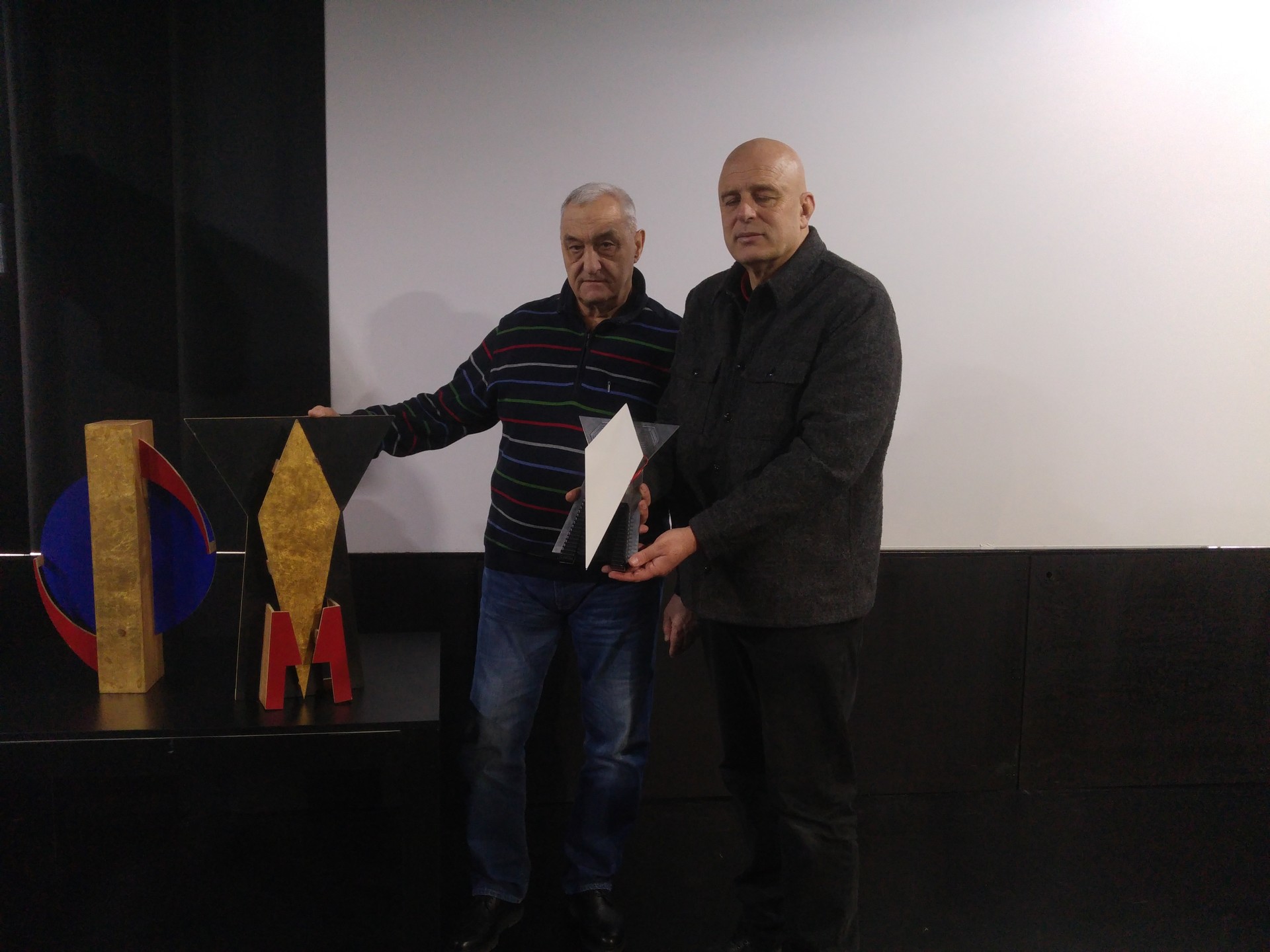 Dmitrij Dragun (Akademija Ciolkovskega) in Dragan Živadinov z maketo prvega umetniškega satelita in znakom pokojne igralke Milene Grm.
