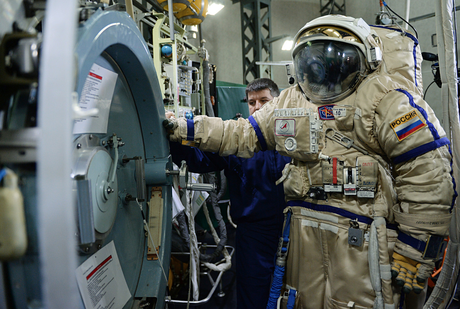 An output hatch VL-1 of one of the modules of the ISS and an Orlan MK Russian spacewalking spacesuit at the Yuri Gagarin Cosmonaut Training Center.