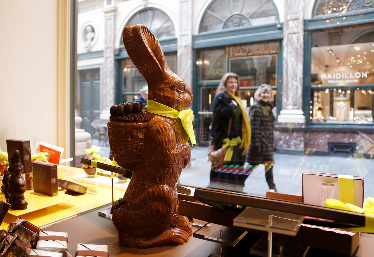 Dua perempuan berjalan melewati cokelat kelinci Paskah di toko pembuat cokelat Belgia Neuhaus di Brussel.