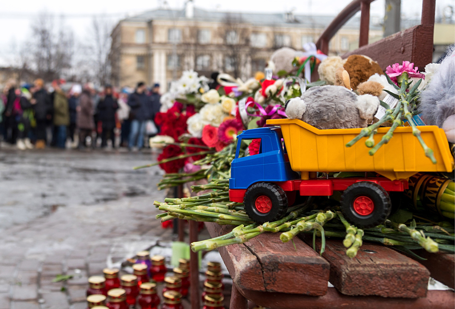 Karangan bunga, lilin, dan mainan dari warga kota yang berduka di luar pusat perbelanjaan Zimnyaya Vishnya.