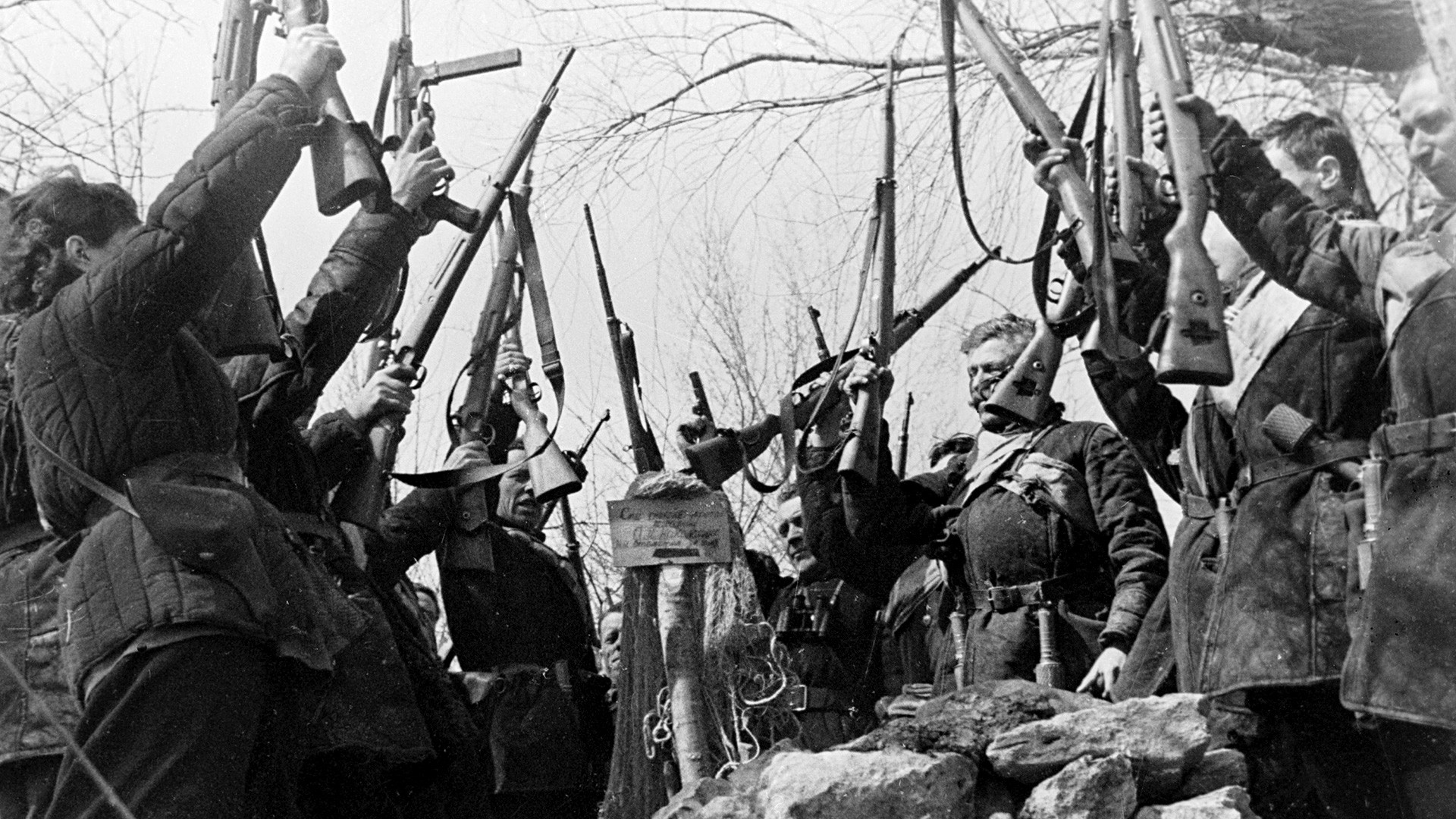 Guerrillas swearing to revenge for their comrade killed by the Nazis near his tomb.