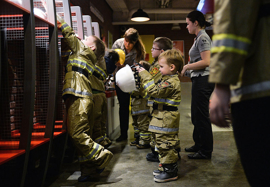 Children learning fire-extinguishing skills at the fireman area of the Kidzania game training park in Moscow.